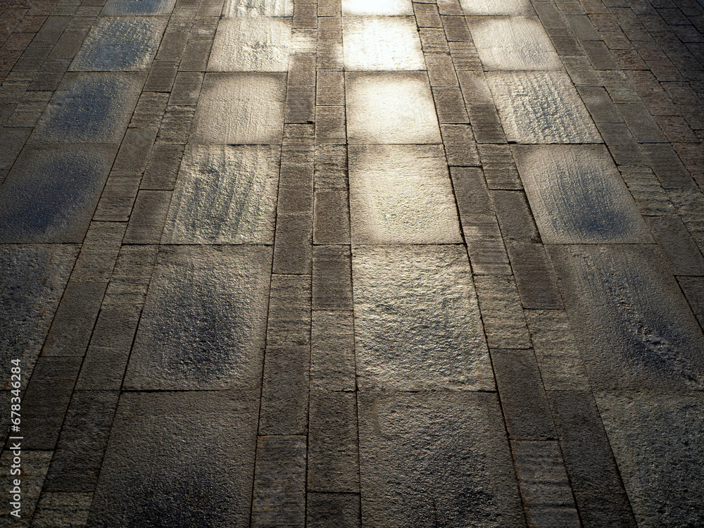 Poster the wet, shiny stone pavement is laid in rows of rectangular tiles. the sidewalk moves forward in pe