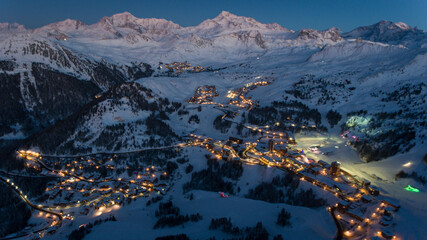 Alpine resort lights twinkle at twilight.
