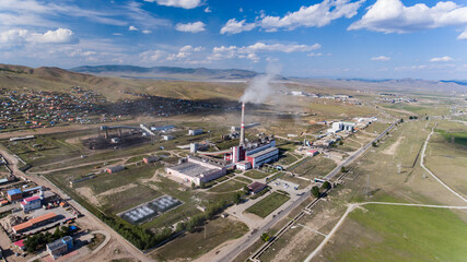 Factory smokestacks towering over a Mongolian town