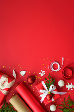 Christmas Present box and decorations at red background. Wrapping christmas present. Vertical.