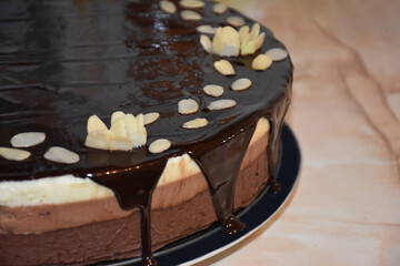 Homemade triple chocolate mousse cake with chocolate mirror glaze and almond flakes