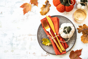 Craft plate, cutlery and autumn decorations on white background. Flat lay.