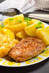 Minced pork cutlet served with potatoes and sauerkraut salad.