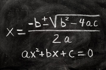 Fototapeta na wymiar Ecuaciones cuadráticas escrito a mano en una pizarra con tiza, fórmulas matemáticas