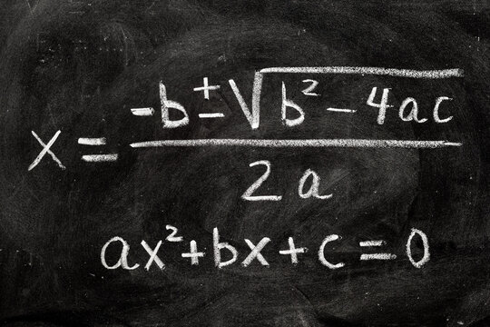 Ecuaciones cuadráticas escrito a mano en una pizarra con tiza, fórmulas matemáticas