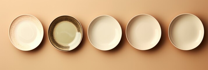 A chic set of minimalistic porcelain dining plates isolated on a taupe gradient background 