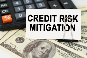 On the dollars there is a calculator and a business card with the inscription - CREDIT RISK MITIGATION