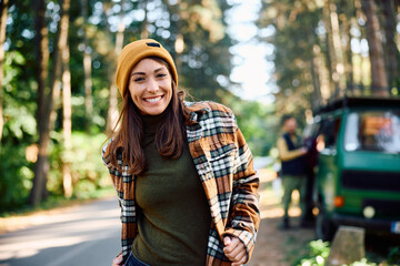 Young happy woman enjoying in camping journey in nature and looking at camera.