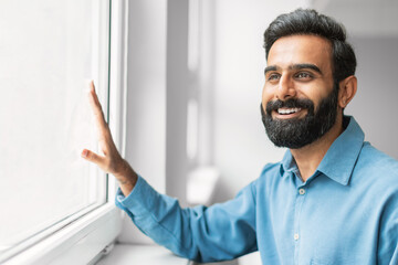 Happy indian businessman smiling by the window
