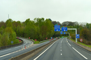 Exit from the road, interchange on the motorway in the forest in France in the spring.