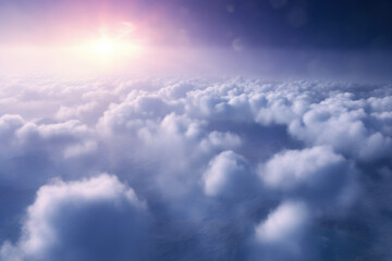Fototapeta na wymiar Fluffy clouds with the sun casting a soft glow in a clear blue sky