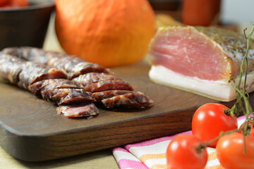 Homemade Chunks of salted bacon, pork lard , Dry salami sausage close-up on the wooden board with...