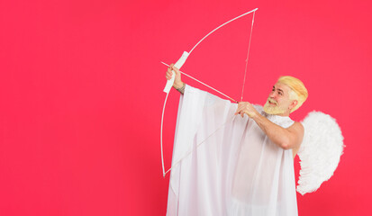 Valentines Day. Smiling bearded man in white angel wings shooting love arrow. Valentines day cupid...