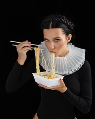 Fashioned Sexy young woman eating pasta. Sensual girl. Female mouth eat spaghetti. Young beautiful model with noodles.