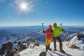 Two tourists at the top of the mountain in winter.