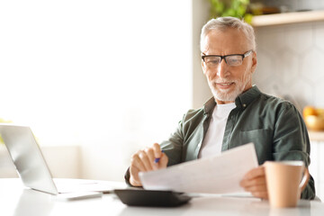 Smiling Senior Man Checking Financial Documents And Calculating Budget At Home
