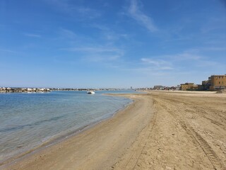 Fototapeta na wymiar Endless long beach in Rimini, Italy with blue sky