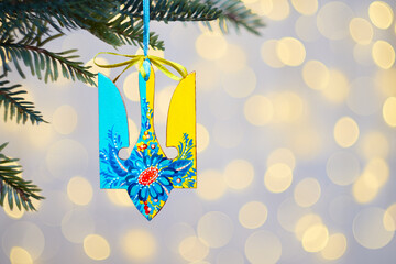 Ukrainian Christmas ornament tryzub. Wooden decoration with Petrykivka painting