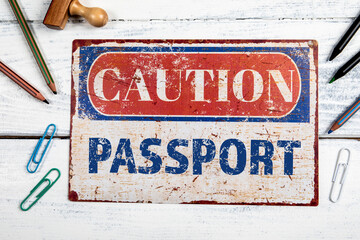 PASSPORT. Metal CAOTION plate with text on a white wooden backgroun