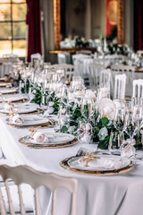 Wedding hall with white chairs, white tablecloths and wine glasses
