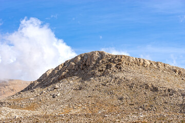 Fototapeta na wymiar Hill of Rocks and Sand Under Beautiful Clouds