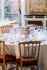 The ceremonial hall for the wedding. White tablecloths, flowers on the table
