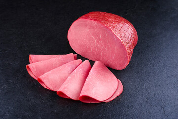 Traditioneller geräucherter Allgäuer Rindersaftschinken aufgeschnitten und am Stück angeboten...