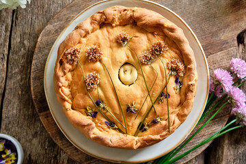 Potato pie decorated with edible flowers. Chives and viola flowers. Spring