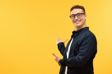 Positive young man showing blank space and smiling