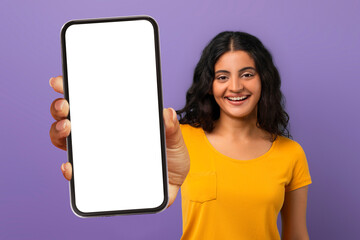 Excited young indian woman showing phone with mockup