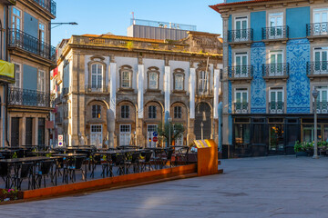 Sidewalk cafe in the city center of Porto with colorful buildings with nobody. Medieval architecture with empty restaurant of Oporto downtown, Portugal at sunrise. Travel destination - obrazy, fototapety, plakaty