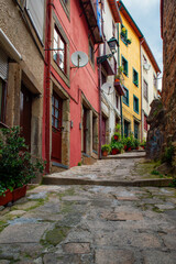 Fototapeta na wymiar Medieval narrow street with colorful buildings in old town of Porto, Portugal with nobody. Medieval architecture of Oporto downtown. Vertical orientation. Travel destination