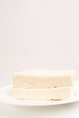 Feta cheese in a white plate on a white background.