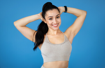 Fototapeta premium Happy sporty attractive young woman in sportswear on blue