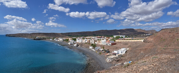 La Lajita, Fuerteventura, Kanarische Inseln, Spanien - Panoramablick über den kompletten Ort mit Strand und Landschaft - obrazy, fototapety, plakaty