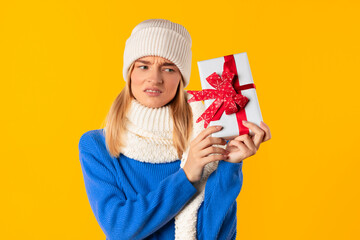 Woman with puzzled expression holding gift