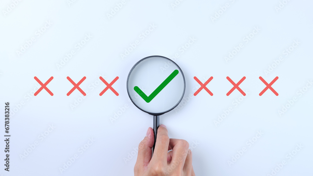 Poster hand holding a magnifying glass to magnify the check mark. correct sign mark inside magnifier glass,