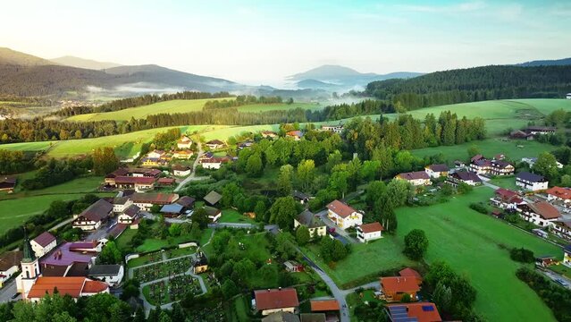 Fairytale aerial view of Bavarian village with mysterious clouds in mountains