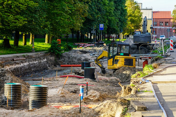 Street reconstruction view, replaced underground pipes, vertical plastic wells, excavators