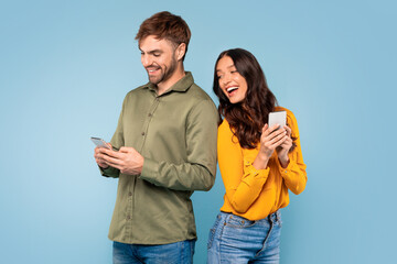 Woman peeks at spouse's phone, blue backdrop