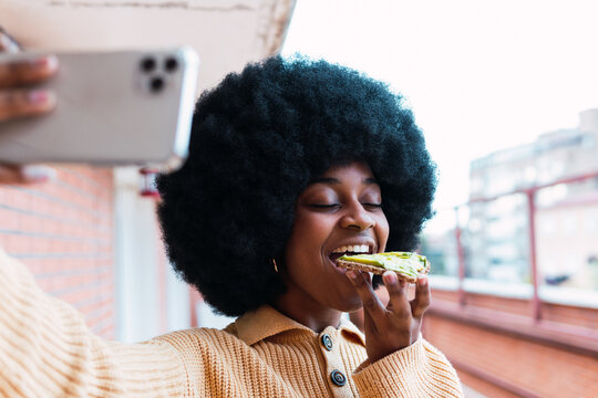 Black woman taking selfie with avocado toast