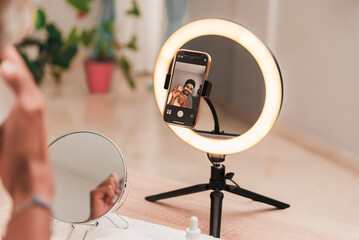 Influencer creating content using ring light and smartphone