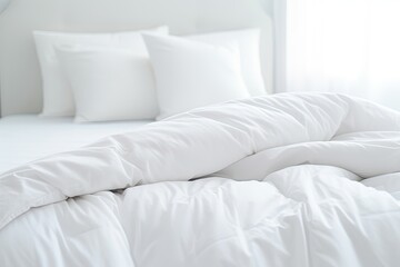 Fototapeta na wymiar White duvet and pillow lying on white bed background.