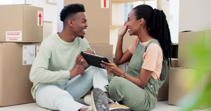 Tablet, high five and a black couple kissing while moving house together with boxes in their apartment. Real estate, property and support with young people in their new home for investment success
