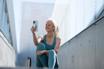 Smiling mature woman taking selfie after workout