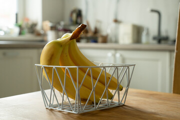 Basket with fresh fruits on table in kitchen