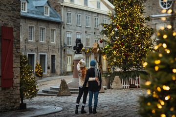 Couple enjoying a festive Christmas street scene in Quebec, Canada