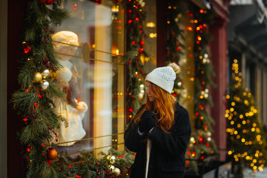 Woman admiring holiday window display in winter in Quebec, Canada