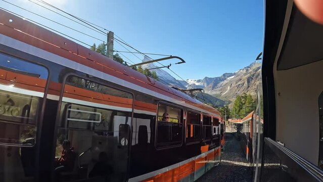 View of the Matterhorn from train while another passes by in Zermatt Switzerland.