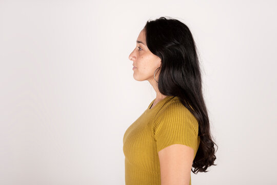 Portrait of a young latin woman in profile on white background
